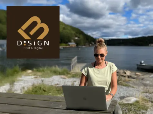 Bild_MB_DSiGN Melanie Bartel am Tisch vor Laptop im Hintergrund ein See
