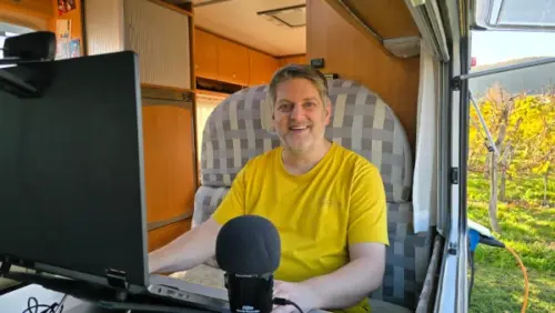 André Christen sitzt am Laptop im Wohnmobil