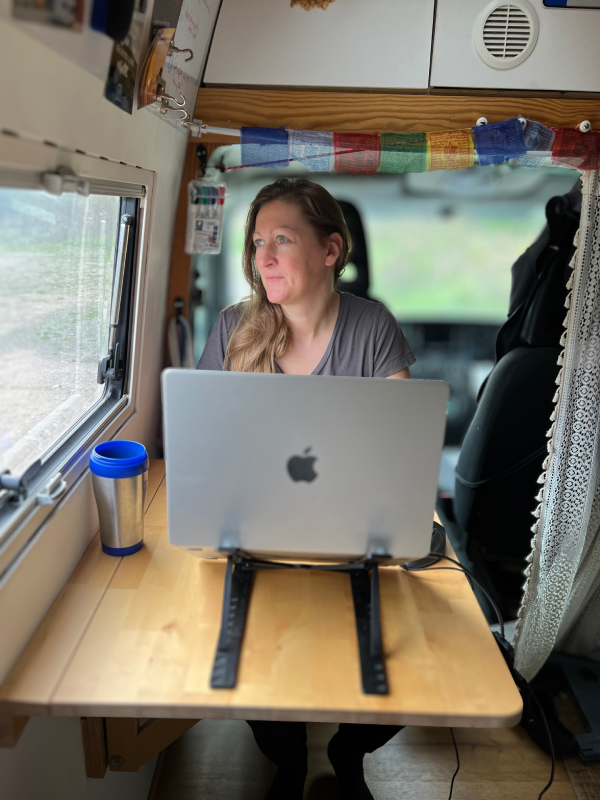 Anja im Camper mit Mac Blick aus dem Fenster